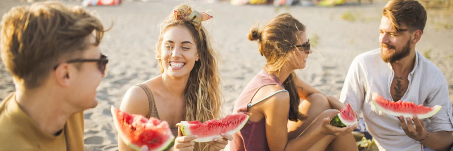 Personen am Strand mit Wassermelone.